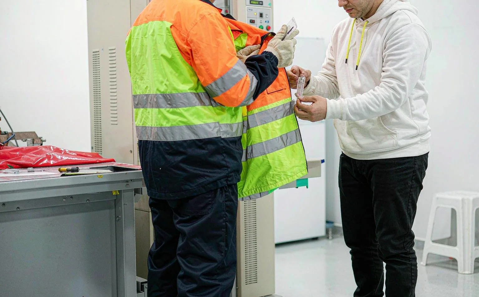 Inspectors checking EN ISO 20471 hi-vis workwear compliance in a testing lab